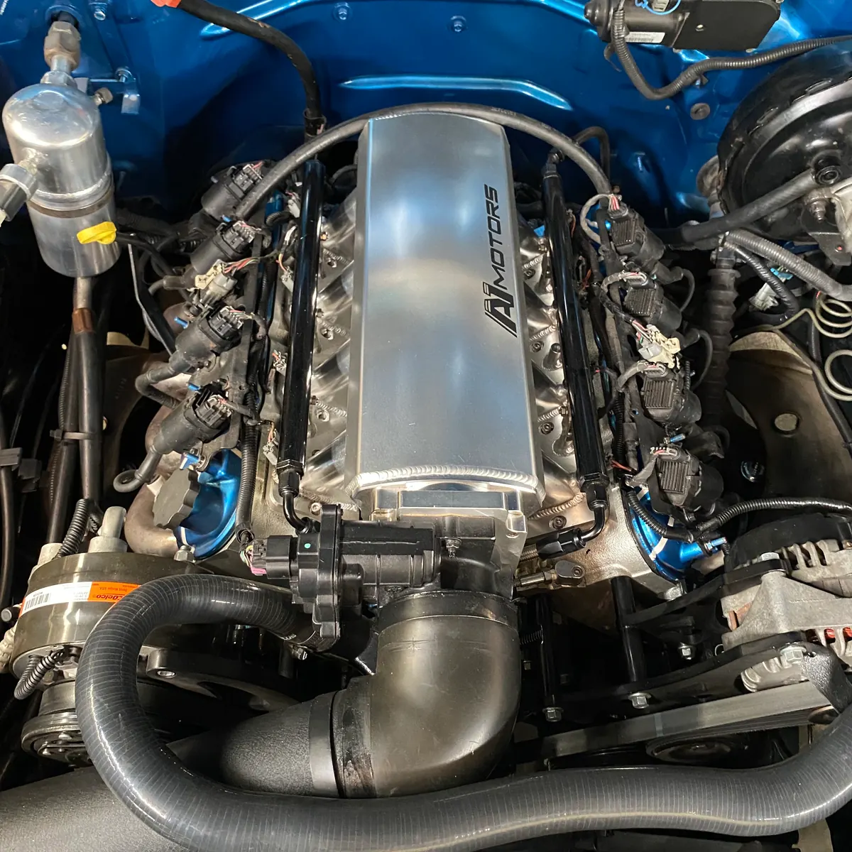 Motor LS instalado en compartimiento azul con múltiple de admisión personalizado A1 Motors y cableado ordenado
