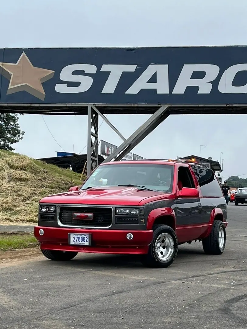 Chevrolet Tahoe de dos puertas rojo y gris con swap LS en el autódromo, con placa de Costa Rica