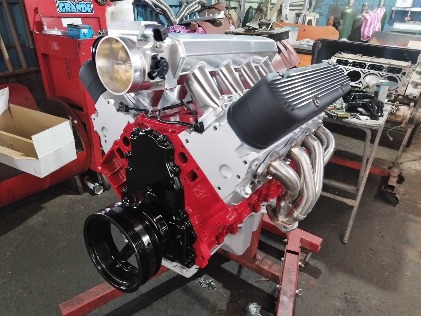 El LS 5.3 armado sobre el banco con el bloque pintado de rojo, tapas de balancines negras y múltiples de escape tipo header en acero inoxidable